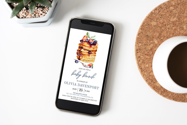 May include: A digital invitation for a baby brunch in honor of Olivia Davenport. The invitation features a watercolor illustration of a stack of pancakes with blueberries, strawberries, and maple syrup. The text reads "Join us for a baby brunch in honor of Olivia Davenport, Aug 25 | 11 AM, The Miller's House, 123 The Party Rd, Philadelphia, PA. Kindly RSVP by Aug 10 at 123-456-7890. Registered at Baby Shop."