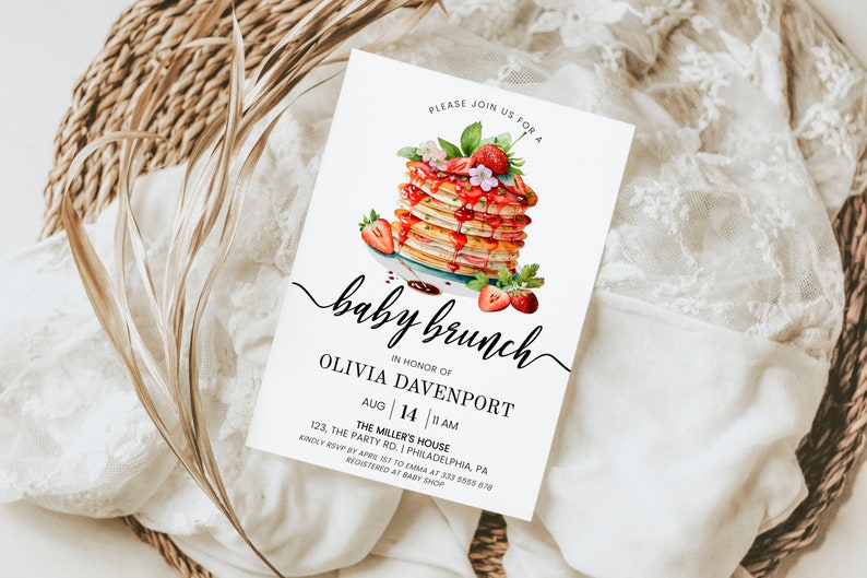 May include: A white baby shower invitation with a watercolor illustration of a stack of pancakes topped with strawberries and syrup. The text reads "Please join us for a baby brunch in honor of Olivia Davenport, Aug 14, 11 AM, The Miller's House, 123, The Party Rd., Philadelphia, PA. Kindly RSVP by April 1st to Emma at 333 5500 678. Registered at Baby Shop."