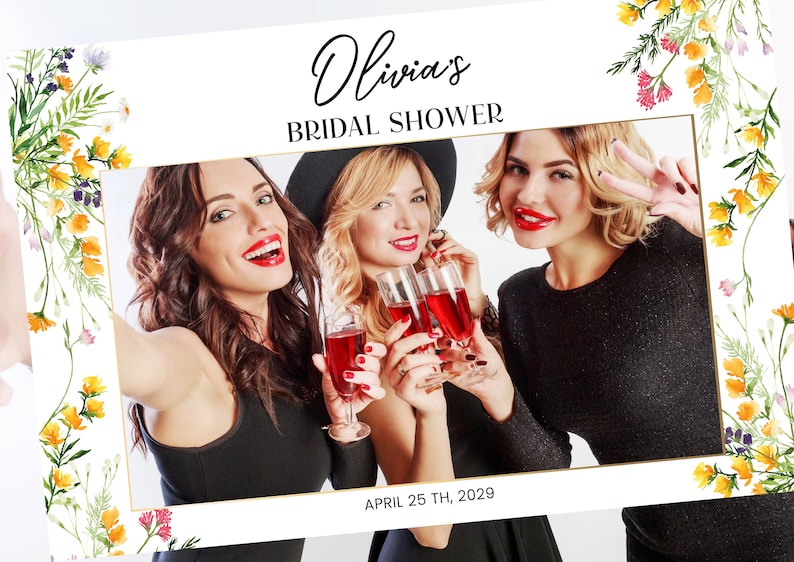 May include: A white photo booth prop with a floral border and gold trim. The text "Olivia's Bridal Shower" is at the top of the frame. The date "APRIL 25 TH, 2029" is at the bottom of the frame.