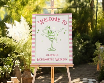 May include: Welcome to Olivia's Bachelorette Weekend sign with a pink and white striped background. A green line drawing of a woman in a cocktail glass is featured on the sign.