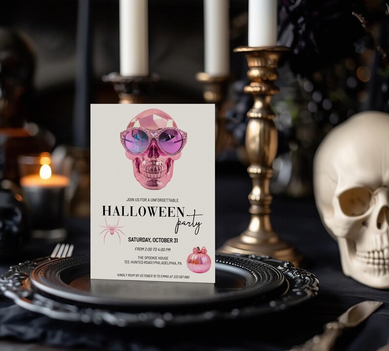 May include: A pink Halloween party invitation featuring a pink skull wearing sunglasses and a spider. The text reads "Join us for an unforgettable Halloween party, Saturday, October 31, from 2:00 to 4:00 PM, The Spookie House, 033 Haunted Road, Philadelphia, PA. Kindly RSVP by 27 October to Emma at 215-555-0000."