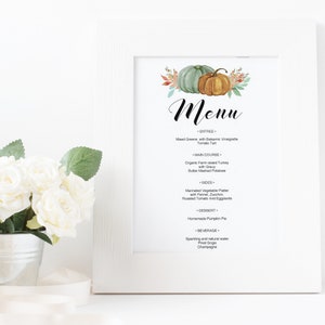 May include: A printable Thanksgiving menu featuring a watercolour illustration of pumpkins and autumn foliage. The menu lists dishes such as mixed greens with balsamic vinaigrette, organic farm-raised turkey, and homemade pumpkin pie.