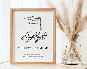 Op de afbeelding: Een ingelijst bord met een illustratie van een afstudeerhoed en de tekst "Highlight Your Favorite Verse. Leave a post-it note of encouragement for Olivia."