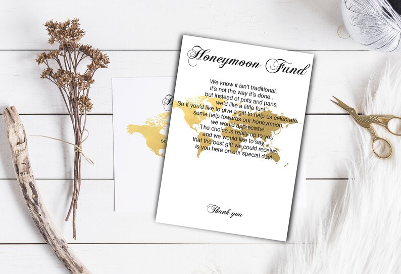 Puede incluir: Una tarjeta blanca con texto dorado y un contorno dorado de un mapa del mundo. El texto dice "Fondo de luna de miel" y explica que en lugar de regalos tradicionales, la pareja apreciar&iacute;a las contribuciones a su luna de miel. La tarjeta termina con "Gracias."