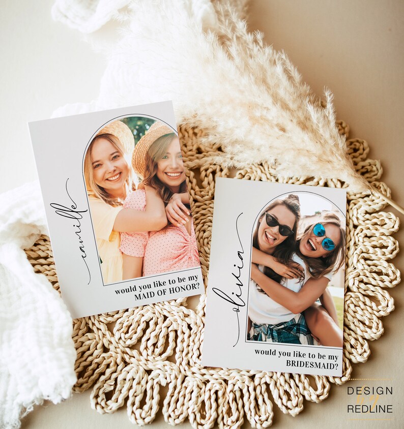 May include: Two cards with a white background and a gray archway design. The cards feature photos of two women each. The text on the cards reads "Camille" and "would you like to be my Maid of Honor?" and "Olivia" and "would you like to be my Bridesmaid?"