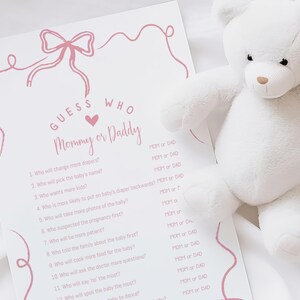 K&ouml;nnte beinhalten: Ein rosa-wei&szlig;es druckbares Babyparty-Spiel mit dem Text "Errate wer Mama oder Papa" und einer Liste von Fragen &uuml;ber die werdenden Eltern.