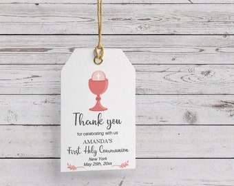May include: White thank you tag with a pink chalice and host, with the text "Thank you for celebrating with us AMANDA'S First Holy Communion New York May 25th, 20xx"
