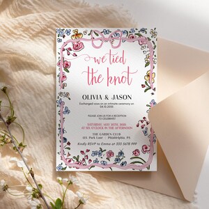 May include: A floral wedding invitation with a pink ribbon tied in a bow. The text reads "We tied the knot" with the names Olivia & Jason and the date 04.10.2055. The invitation also includes details about the reception, which will be held on Saturday, 25th May 2005 at six o'clock in the afternoon at The Garden Club, 123 Park Lane, Philadelphia, PA. The RSVP information is "Kindly RSVP to Emma at 355 5678 999."
