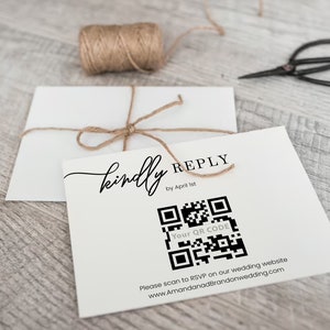 May include: A white card with the text "kindly REPLY by April 1st" and a black and white QR code. The text "Your QR CODE" is below the QR code. The text "Please scan to RSVP on our wedding website www.AmandanadBrandonwedding.com" is below the QR code.