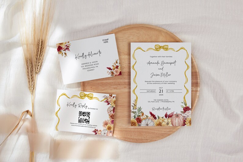 May include: Fall wedding invitation suite with a floral design featuring pumpkins, leaves, and flowers in shades of red, yellow, and white. The invitation includes the names Amanda Buccnport and Jason Miller, the date October 21, 2023, and the location The Garden Hotel.
