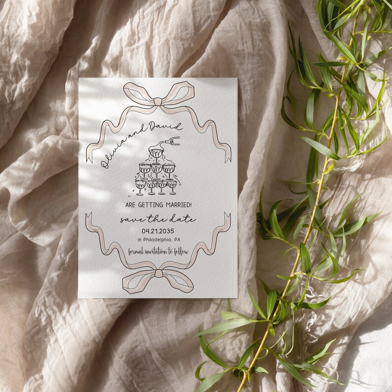 May include: Save the date card with a pink and white ribbon design. The card features a drawing of a champagne tower and the text "Olivia and David are getting married! Save the date 04.21.2035 in Philadelphia, PA. Formal invitation to follow."