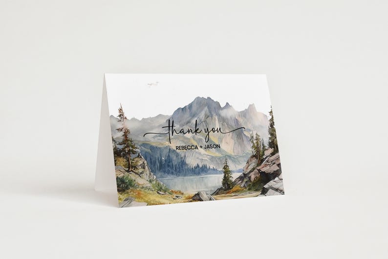 K&ouml;nnte beinhalten: Eine Aquarell-Dankeskarte mit einer Bergszene. Die Karte zeigt einen See, Berge, B&auml;ume und den Text "Danke" mit den Namen "Rebecca + Jason" darunter.