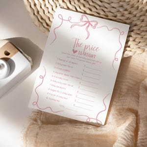 K&ouml;nnte beinhalten: Eine rosa und wei&szlig;e druckbare Babyparty-Spielkarte mit dem Text "Der Preis ist richtig". Das Spiel fordert die G&auml;ste auf, den Preis verschiedener Babyartikel zu erraten.
