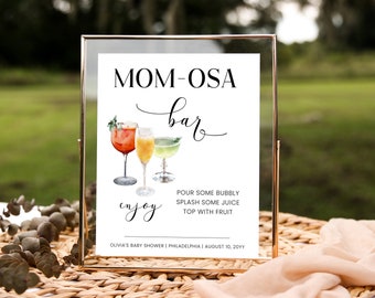 May include: A white sign with black text that reads "MOM-OSA bar" with a handwritten script font. The sign also includes a watercolor illustration of three cocktails and the text "enjoy". The sign also includes instructions for making the cocktails: "Pour some bubbly, splash some juice, top with fruit". The sign also includes the text "Olivia's Baby Shower | Philadelphia | August 10, 20YY".