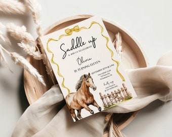 May include: A white invitation with a gold ribbon border and a watercolour illustration of a brown horse. The text reads "Saddle up & join us to celebrate Olivia is turning eleven September 30th @ 3 PM The Horse Club 123 Party Rd Philadelphia PA  Kindly RSVP mom Pauline @ 333 56789 000"