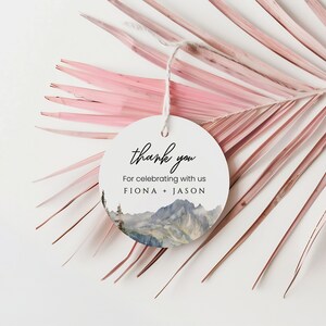 May include: Round white thank you tag with a watercolor mountain scene and the text "thank you" and "For celebrating with us FIONA + JASON".