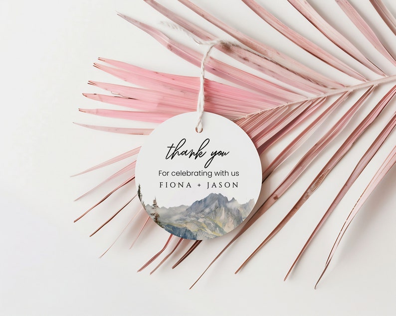 May include: Round white thank you tag with a watercolor mountain scene and the text "thank you" and "For celebrating with us FIONA + JASON".