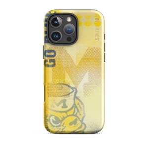 Pode incluir: Uma capa de smartphone amarela e branca com um gráfico de uma mascote usando um chapéu com a letra M, o texto GO BLUE e a palavra WOLVERINES. O design inclui uma letra M grande no fundo com um padrão de pontos.
