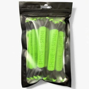 May include: A black plastic resealable pouch containing multiple lime green cylindrical items. Each item features the text SHINE SPINE embossed on the surface. The pouch has a clear rectangular window in the center, allowing the contents to be visible.