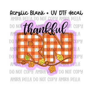May include: An acrylic blank with a UV DTF decal featuring the text thankful RN in black script over large block letters with an orange and white buffalo plaid pattern, accented by a vine of yellow and green autumn leaves on a light purple background.