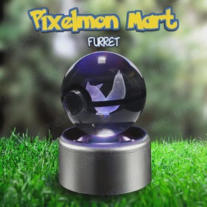 Puede incluir: Una esfera de cristal transparente con una figura de Furret grabada con láser en su interior, sobre una base cilíndrica plateada. El texto Pixelmon Mart y FURRET aparece sobre la esfera, que recuerda a una bola con una banda oscura.