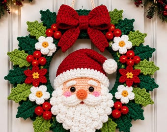 May include: A crocheted Christmas wreath featuring a central Santa Claus face with a red hat and white beard. The wreath is decorated with green crocheted holly leaves, red berries, white flowers, and a large red bow at the top with a hanging cord.