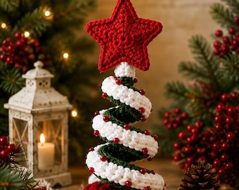 May include: A spiral-shaped crochet Christmas tree decoration featuring a dark green base, a white crocheted garland wrapped around the center, small red beads accenting the white yarn, and a large red five-pointed star topper.