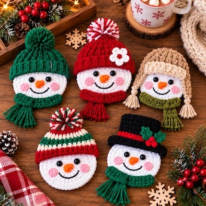 May include: Five crocheted snowman ornaments featuring white faces with orange noses, black eyes, and pink cheeks. Each snowman wears a unique hat, including beanies with pom-poms, a trapper hat with braids, and a black top hat with holly berries.
