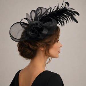 Peut inclure: Un bibi noir composé de tissu sinamay transparent en boucles disposées en motif circulaire, agrémenté de deux rosettes centrales en tissu et d'un groupe de longues plumes noires fines s'étendant sur le côté de la coiffe.