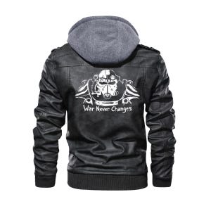 May include: A black faux leather jacket featuring a grey fabric hood and a white graphic print on the back. The print depicts a power armor helmet from the Fallout series with the text War Never Changes written underneath in a stylized white font.