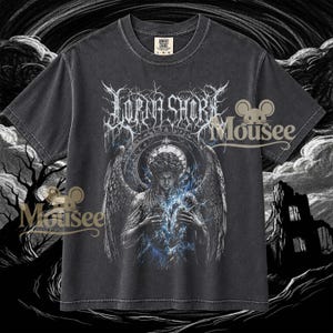Pode incluir: Uma t-shirt cinza-carvão de manga curta com uma estampa gráfica de uma figura alada com raios azuis emanando do peito. O texto "LORNA SHORE" está impresso numa fonte branca estilizada acima da figura, com um design circular por trás.