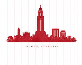 Puede incluir: Una silueta roja del horizonte de Lincoln, Nebraska, que presenta el Capitolio del Estado de Nebraska como punto focal central, sobre un fondo blanco con líneas verticales y el texto LINCOLN, NEBRASKA impreso debajo.