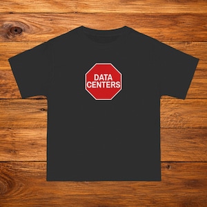 Op de afbeelding: Een zwart t-shirt met korte mouwen en een rode achthoekige afbeelding op de borst. De afbeelding lijkt op een stopbord met een witte rand en de witte tekst "DATA CENTERS" in het midden gedrukt in een vet, schreefloos hoofdlettertype.