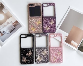 May include: Five foldable phone cases arranged in a group, each featuring a textured surface covered in small beads and two butterfly embellishments. The cases come in various colors including beige, purple, black, dark gray, and light pink.