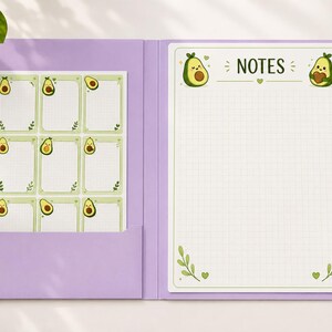 May include: A light purple folder containing a grid-lined notepad with the word NOTES and cartoon avocado illustrations at the top, alongside a sheet of nine smaller grid-lined avocado-themed note cards tucked into the folder pocket.
