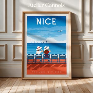 Peut inclure: Une affiche de voyage encadrée intitulée NICE montrant un ciel bleu avec un avion, une mer avec des voiliers et deux personnes portant des chapeaux blancs assises sur des chaises bleues sur une terrasse rouge. Texte NICE et FRENCH RIVIERA.