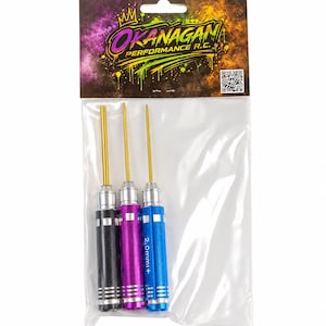 Könnte beinhalten: Ein Set aus drei Präzisionsschraubendrehern mit goldfarbenen Spitzen und strukturierten Griffen in Schwarz, Lila und Blau, verpackt in einem durchsichtigen Plastikbeutel mit einer Kopfkarte OKANAGAN PERFORMANCE R.C. und einem QR-Code.