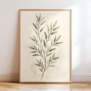 Könnte beinhalten: Ein gerahmter Kunstdruck mit einer Aquarellillustration eines grünen Zweigs mit Blättern und kleinen Knospen. Das botanische Kunstwerk ist auf einem hellen cremefarbenen Hintergrund zentriert und von einem dünnen, hellen Holzrahmen umgeben.