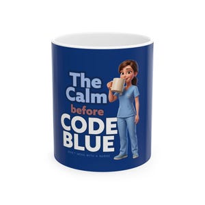 Può includere: Una tazza in ceramica blu scuro con un'infermiera in stile cartoon che indossa una divisa azzurra e tiene in mano una tazza beige. Il testo recita The Calm before CODE BLUE e DON'T MESS WITH A NURSE in bianco e rosa chiaro su sfondo blu.