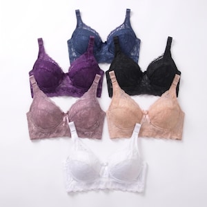 May include: A collection of six lace bras in navy blue, purple, black, mauve, beige, and white. Each bra features molded cups, adjustable shoulder straps, a wide lace underband, and a small central bow detail on the bridge between the cups.