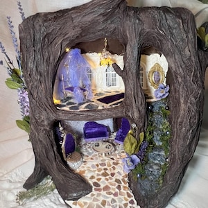 May include: A two-story miniature tree house diorama featuring a dark brown textured bark exterior. The interior includes a purple velvet bed with a canopy, a purple velvet seating area, a stone-tiled floor, a chandelier, and a stone staircase.
