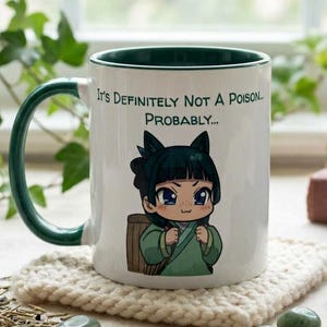 Könnte beinhalten: Ein weißer Keramikbecher mit dunkelgrünem Innenraum und Henkel. Auf der Vorderseite ist eine Zeichentrickfigur mit dunklem Haar und grünem Gewand abgebildet, begleitet von dem Text: It's Definitely Not A Poison... Probably...