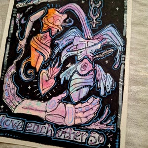 May include: A watercolor painting on black paper with a blue, pink, and orange abstract design. The painting features the text "Closer than you know" and "love each other so".