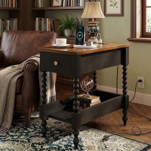 May include: A rectangular end table with a dark wood finish, featuring a single drawer with a gold knob, a lower shelf, and four turned spindle legs. The top surface holds a white wireless charging station with a smartphone and a smartwatch.