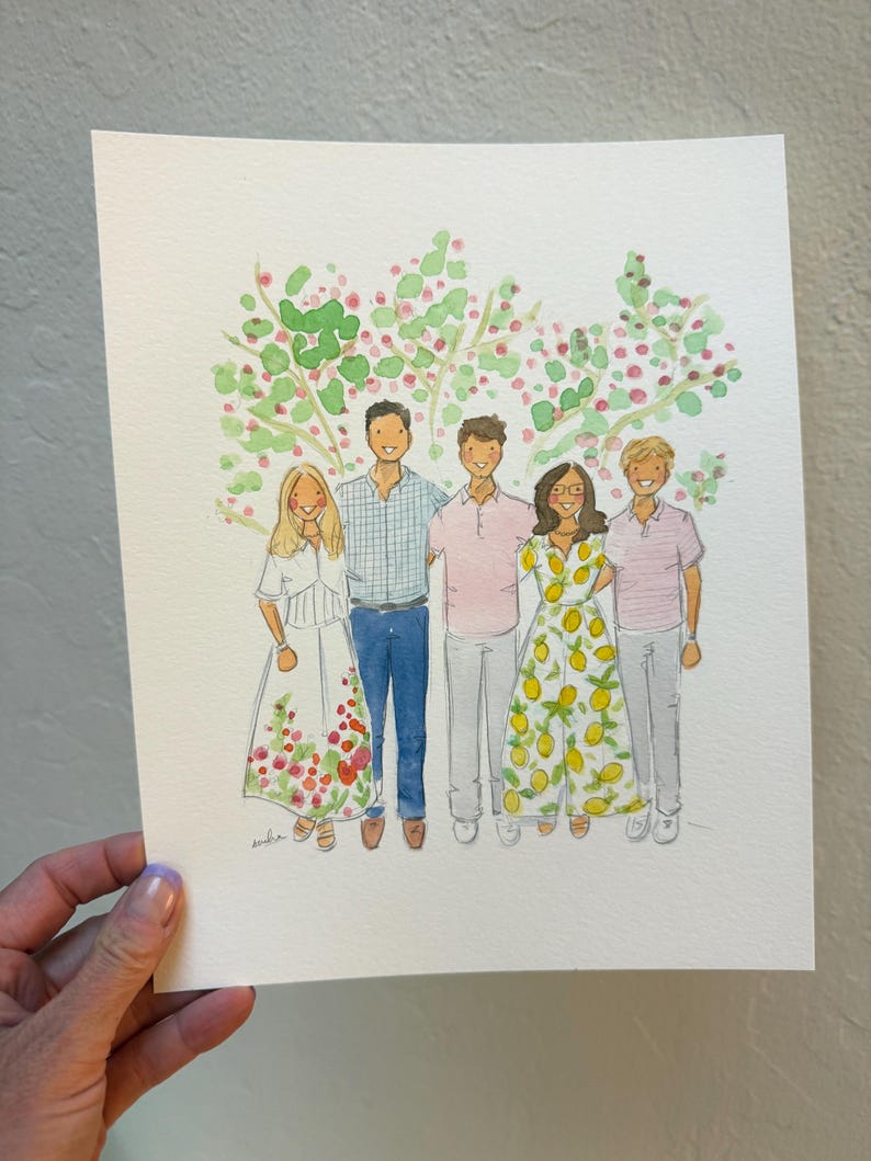May include: Watercolor portrait of five people standing in front of a tree with green and pink foliage. The people are wearing various outfits, including dresses and shirts. The artwork is on white paper and held by a hand.