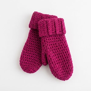 May include: A pair of vibrant magenta mittens crafted with a chunky crochet knit texture. The mittens feature a prominent ribbed cuff that is folded over, providing a thick and textured appearance throughout the hand and thumb sections.
