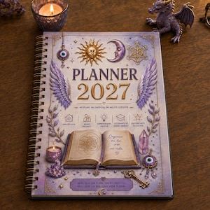 Pode incluir: Uma agenda 2027 de espiral com capa em tons de lavanda e dourado, ilustrada com sol, lua, asas, um livro aberto, cristais e amuletos. O texto inclui PLANNER 2027, MI PLAN, MI ENERGÍA, MI MEJOR VERSIÓN e outras frases impressas na capa.