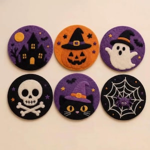 以下が含まれることがあります： ハロウィーンのデザインが施された6枚の円形フェルトコースターセット。紫地に黒いお化け屋敷、魔女の帽子をかぶったオレンジ色のジャック・オー・ランタン、紫地に白いお化け、黒地に白い頭蓋骨と交差した骨、紫の魔女の帽子をかぶった黒猫、白いクモの巣に紫のクモが描かれています。