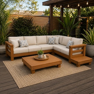 May include: An L-shaped outdoor sectional sofa made of light brown wood with thick beige cushions and patterned throw pillows. A matching square wooden coffee table sits in front, holding a small potted plant and a white candle in a glass jar.