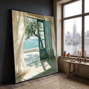 May include: A large rectangular framed wall art print depicting an open turquoise door leading to a sunlit terrace with a view of the sea and a tree. Sheer white curtains hang to the left, and a small wooden chair sits on the tiled floor.